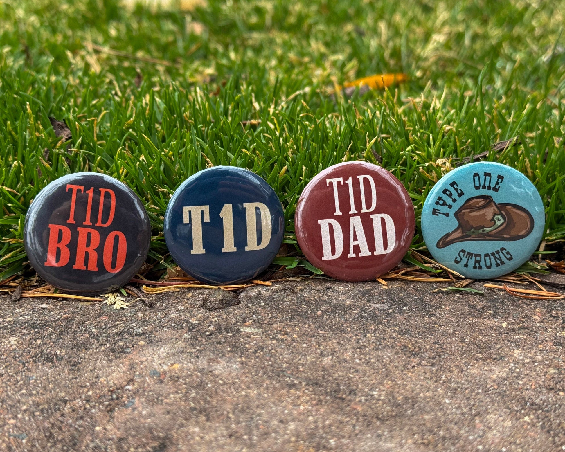 Four diabetes awareness buttons with text on a grassy background